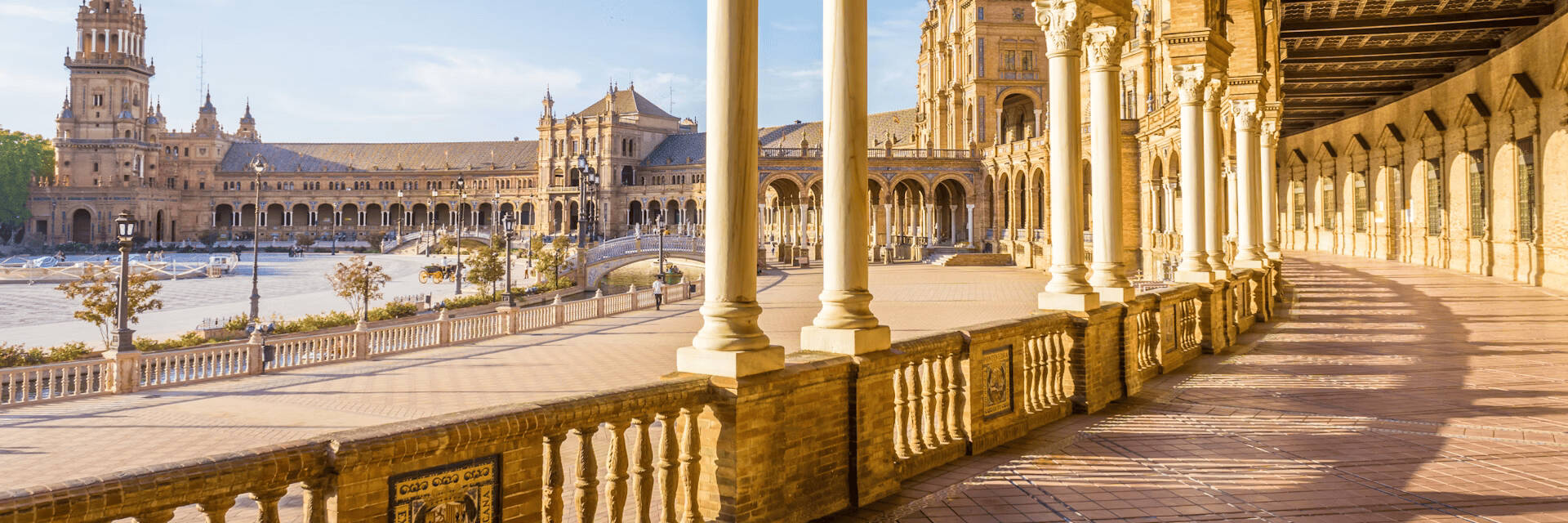 A long building with a pillared exterior walkway is adjacent to a river